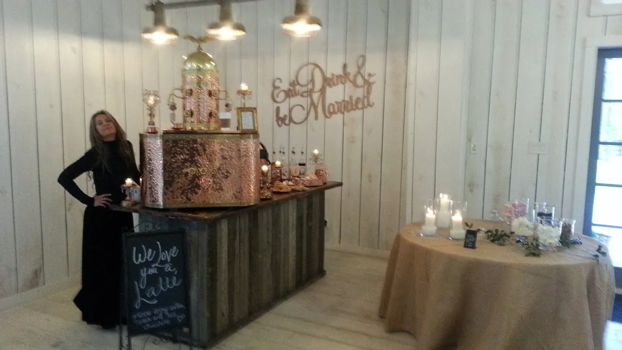 A member of the Chic Coffee Events team beside the copper espresso bar at a wedding