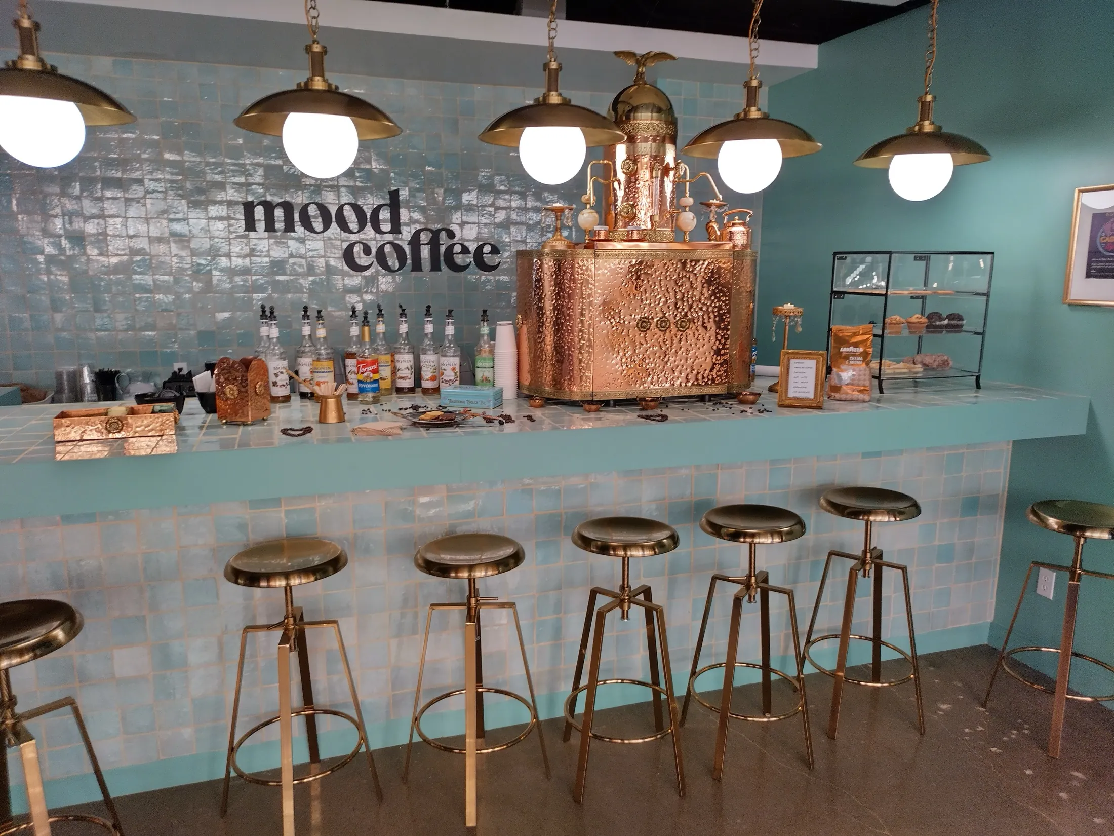 Chic Coffee Events' sculptural copper espresso machine on a blue tiled bar